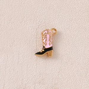 Detailed close-up of a pink and black enamel cowboy boot charm for DIY jewelry crafting