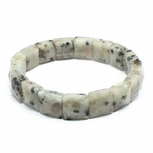 Detailed macro shot of natural dalmatian jasper stones on a faceted square bead bracelet