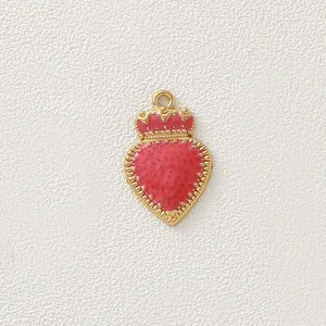 Dettaglio macro di ciondolo cuore in smalto rosso con corona dorata per creazione gioielli
