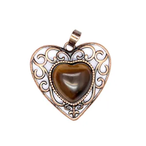 Close-up of vintage bronze hollow heart pendant with polished tiger eye stone