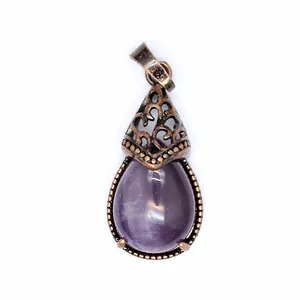 Detailed macro view of a vintage teardrop purple natural stone pendant with bronze filigree.