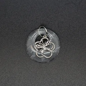 Vue détaillée d'un pendentif en agate naturelle avec filigrane de papillon en argent