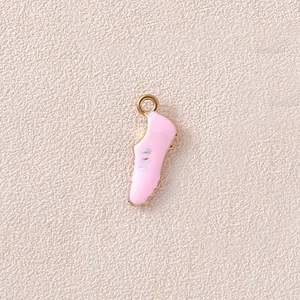 Macro shot of a light pink enamel sneaker charm with golden metal trim for DIY jewelry