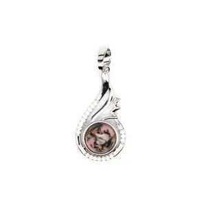 Detail view of a polished pink natural stone pendant set in a shiny silver teardrop frame.