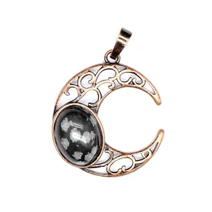Close-up of antique hollow moon pendant with snowflake obsidian stone inlay