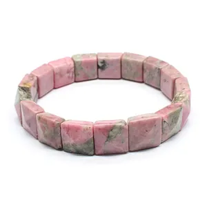 Close-up of natural pink rhodonite stone bracelet with faceted square beads on white background
