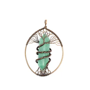 Detail of handmade copper wire-wrapped tree of life pendant with green crystal.