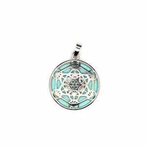 Gedetailleerde weergave van turquoise hanger met een zilveren holle geometrische ster.