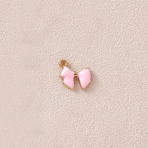 Detail eines rosa Emaille-Schleifenanhängers mit Goldplattierung für DIY-Schmuckherstellung.