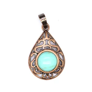 Close-up of teardrop turquoise stone pendant with antique copper hollow filigree