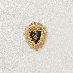 Dettaglio di un ciondolo a cuore placcato oro con smalto nero e cornice a raggiera