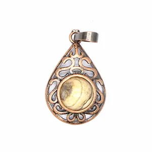 Macro detail of vintage style teardrop pendant with filigree design and natural stone inset