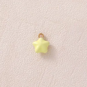 Detail eines kleinen gelben Sternanhängers mit vergoldetem Ring für DIY-Schmuckherstellung
