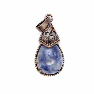 Close-up of a vintage teardrop pendant with blue mottled stone and filigree metal