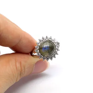 Close-up of adjustable micro-pave ring with round labradorite stone held by fingers