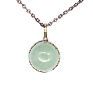 Close-up detail of a vintage bronze necklace featuring a green round natural stone pendant