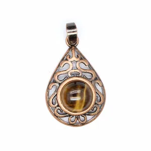 Close-up of vintage hollow teardrop pendant with round tiger eye gemstone detail