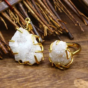 Macro detail of natural white druzy crystal pendant and ring with gold wire wrap design