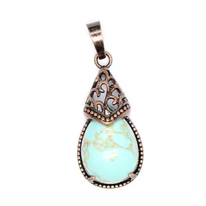 Detailed macro view of vintage bronze teardrop pendant featuring turquoise-patterned stone