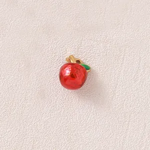 Macro detail of a 3D red apple pendant with gold-plated stem for DIY jewelry