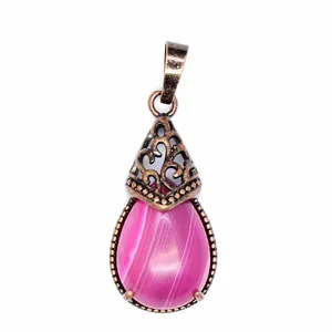 Close-up of teardrop-shaped pink agate pendant with vintage filigree metal cap.