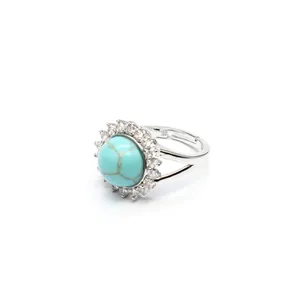 Macro view of adjustable silver ring with round turquoise and micro-paved crystals