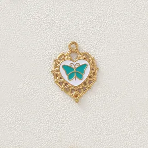 Dettaglio di un ciondolo a cuore dorato vintage con farfalla blu su smalto bianco.