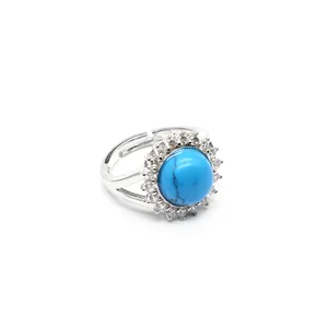Close-up detail of a silver turquoise ring with micro-pave crystal halo and adjustable band
