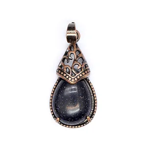 Macro view of a retro blue sandstone teardrop pendant with vintage copper filigree.