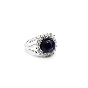 Macro view of adjustable silver ring with deep blue stone and halo of white crystals