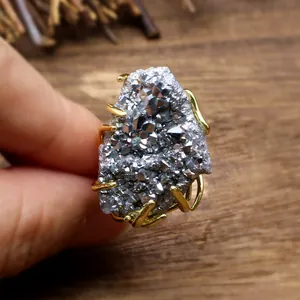 Macro view of a natural silver plated agate druzy stone with a golden wire claw setting