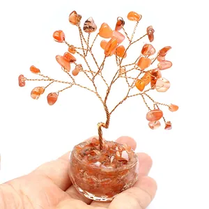 Handcrafted orange carnelian crystal money tree of life decor held in a person's hand