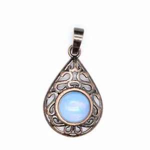 Close-up of vintage hollow teardrop pendant with light blue gemstone in antique bronze finish