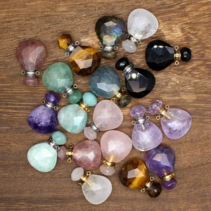 Faceted natural stone teardrop perfume bottle pendants displayed on wooden board