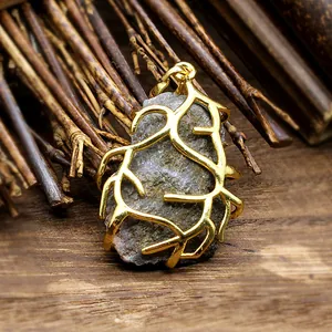 Macro detail of natural stone pendant with gold-plated branch wire wrap cage