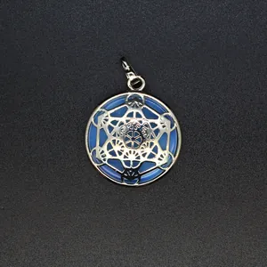 Macrodetail van een zilveren geometrische hanger met blauwe edelsteen inlegstuk.