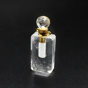 Detailansicht eines klaren Kristall-Parfümflaschen-Anhängers mit goldener Kappe.