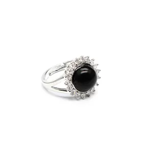Close-up of an adjustable silver ring featuring a black stone with a halo of clear crystals.