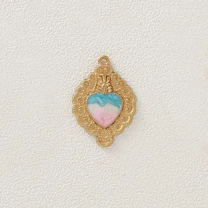 Vista dettagliata del ciondolo a cuore dorato con smalto a vortice blu e rosa chic.