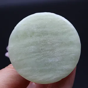 Close-up view of a natural light green round calcite base for chakra stone tree