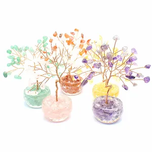 Assorted handmade crystal gemstone money trees with amethyst and rose quartz in glass bowls.