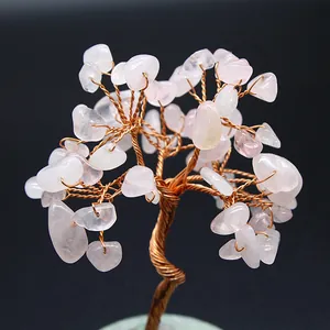Detailed macro view of a handmade rose quartz crystal wire wrapped tree on a green base