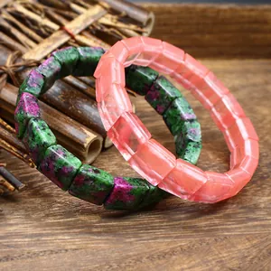 Close-up macro detail of natural stone crystal bracelets with square cut beads on wood