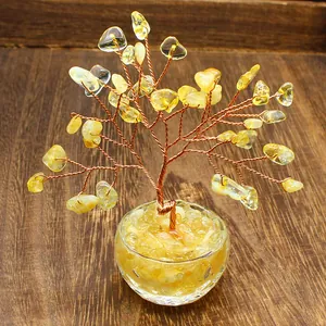 Close-up of a handmade crystal tree of life with yellow stone chips and copper wire.
