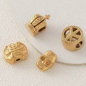 Macro detail of gold plated stainless steel crown and skull charms for jewelry making