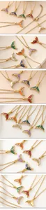 Close-up detail of colorful mermaid tail pendants on gold chains for ocean-inspired style