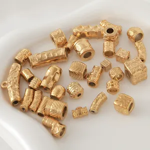 Macro view of assorted gold-plated stainless steel mantra barrel beads for DIY jewelry