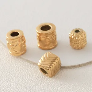 Close-up of gold-plated stainless steel mantra barrel and patterned spacer beads