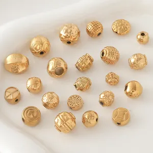 Gros plan de diverses perles en acier inoxydable plaqué or avec gravures pour bijoux DIY