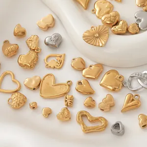 Dettaglio di vari ciondoli a cuore in acciaio inossidabile placcato oro per gioielli fai-da-te.